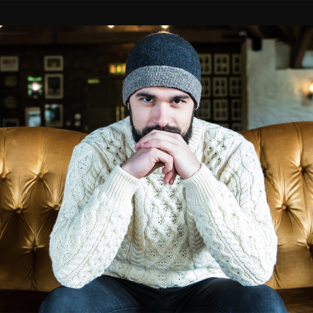 Man wearing charcoal crochet hat & sweater, lifestyle shot