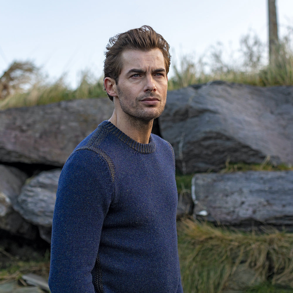 Man in blue sweater looking thoughtful