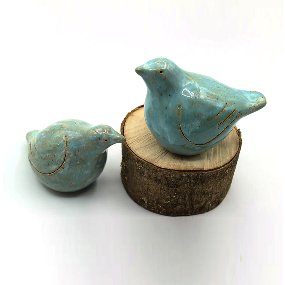 Square turquoise lovebird figurines on wood