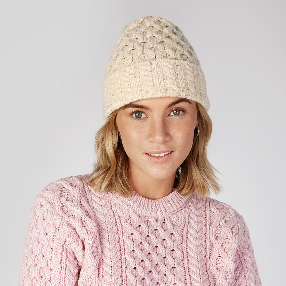 Woman wearing chalkstone knit beanie and pink sweater