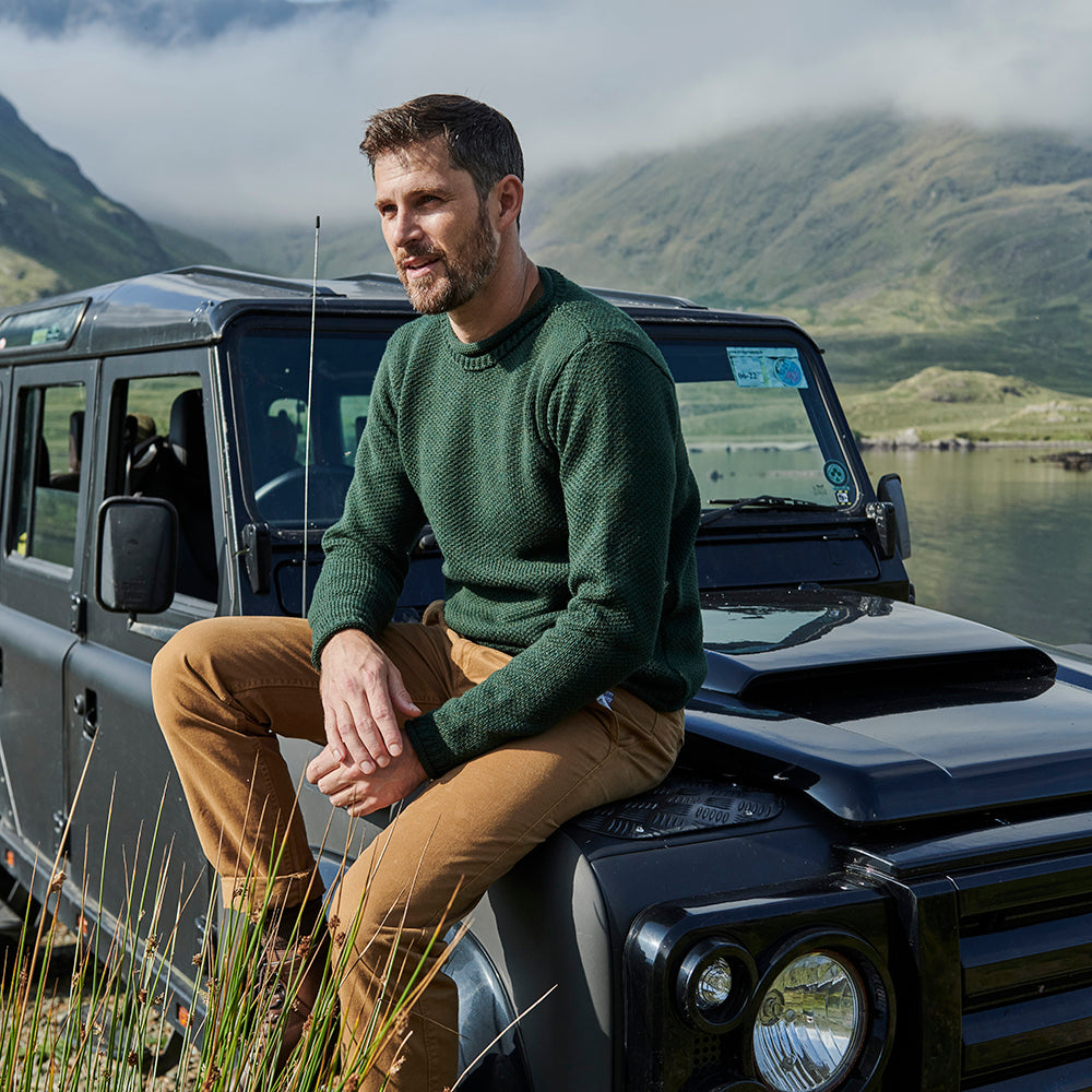 Man in green roll neck sweater on car