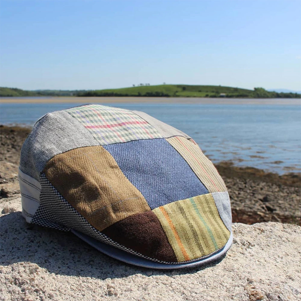 Patchwork tweed cap on a rock by the water