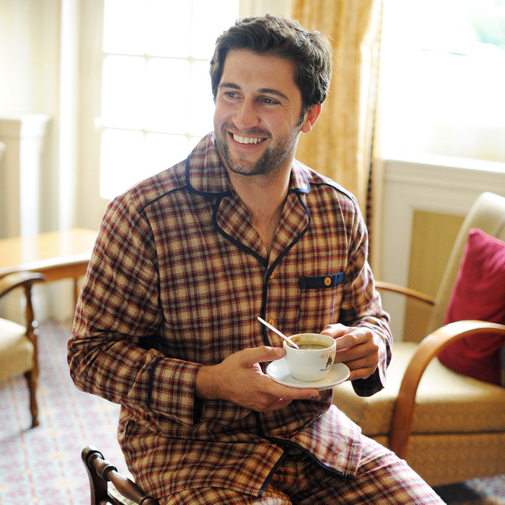 Man in plaid pajamas enjoying coffee