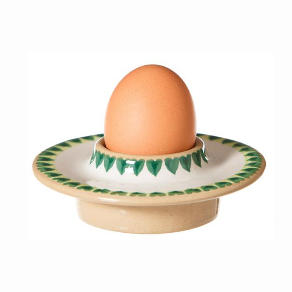 Clover pattern egg cup holding a brown egg