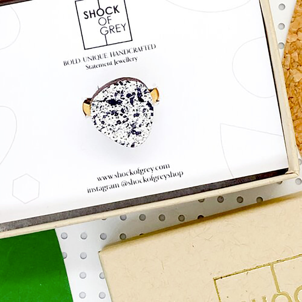 spattered black and white wooden egg ring