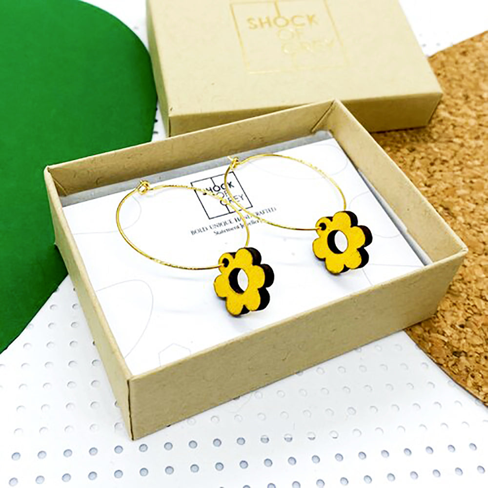 Yellow wooden daisy hoop earrings in a box