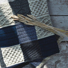 Aran Woollen Mills blue patchwork blanket closeup with wheat