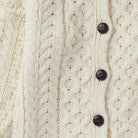 Cream Aran cardigan with buttons, front view.
