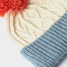 Cream and blue kids Aran wool pom pom hat closeup