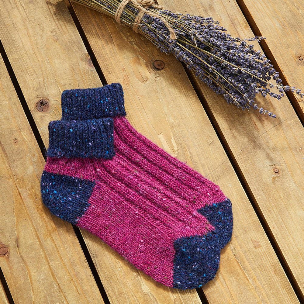 Pink and navy Aran Woollen Mills socks on wood
