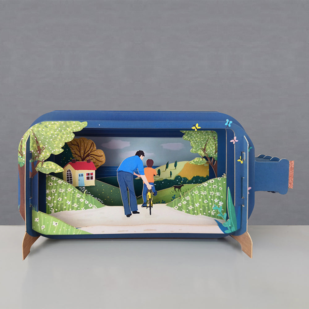 Dad and kid on bike in a message in a bottle diorama.