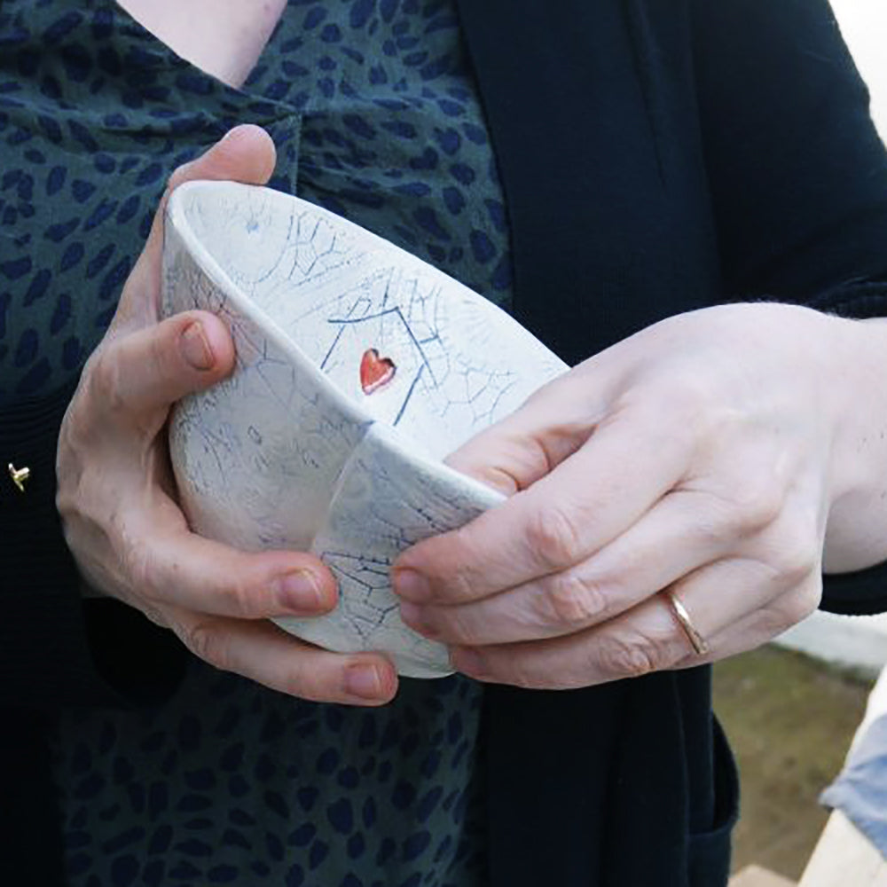 Woman holding decorative bowl with heart design