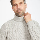 Man in cream Aran polo neck sweater