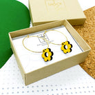 Yellow wooden daisy hoop earrings in a box
